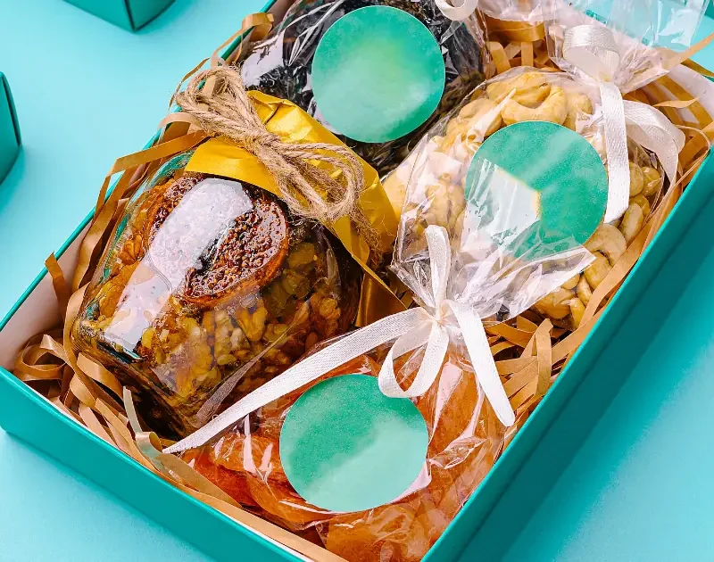 Empaques personalizados para emprendedores colombianos: caja kraft, sticker, fajón y tarjeta