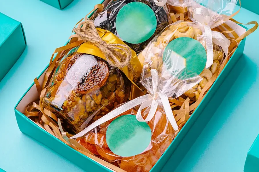 Empaques personalizados para emprendedores colombianos: caja kraft, sticker, fajón y tarjeta