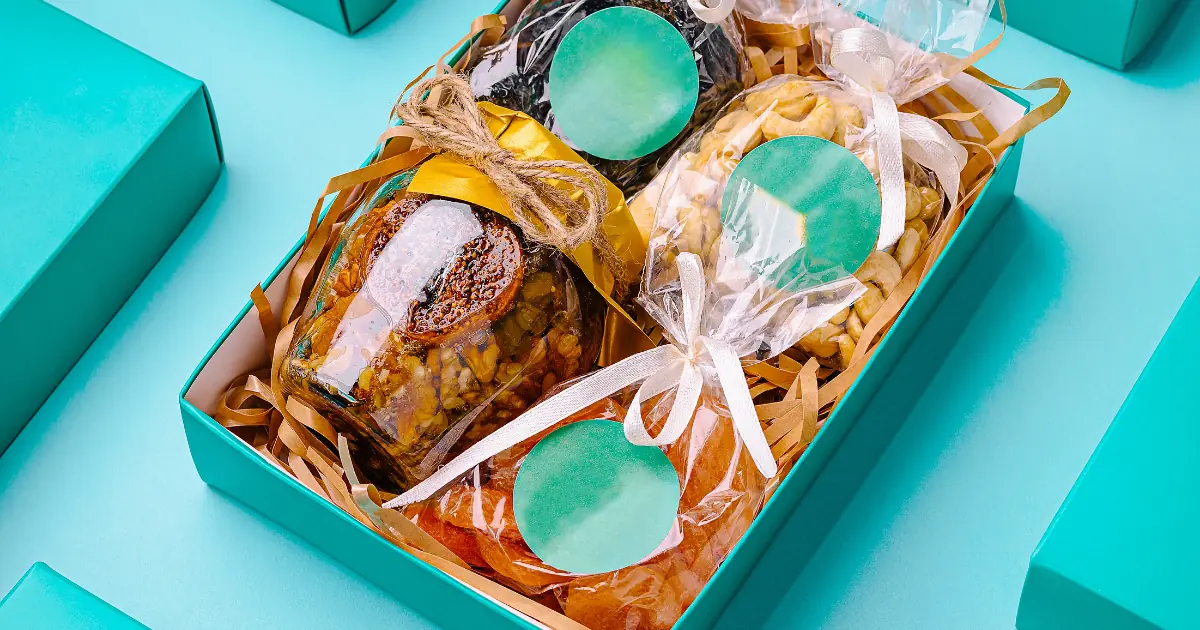 Empaques personalizados para emprendedores colombianos: caja kraft, sticker, fajón y tarjeta